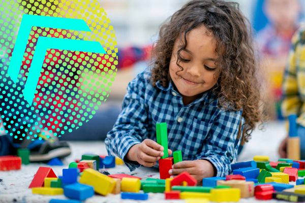 A young child plays with blocks at school. 