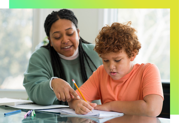 A teacher is helping a student read from a book.