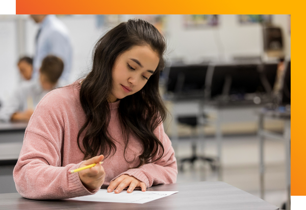 A high school age student focuses on her school work. 