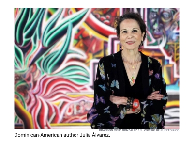 Dominican-American author Julia Alvarez with her arms crossed in front of a mural.