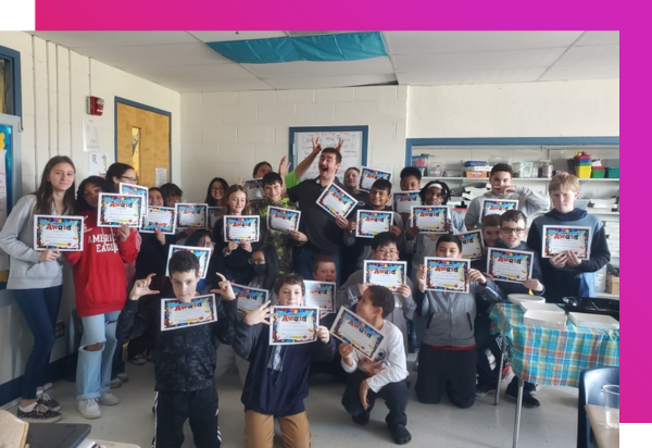 A class of middle school students all holding up MATHia completion certificats