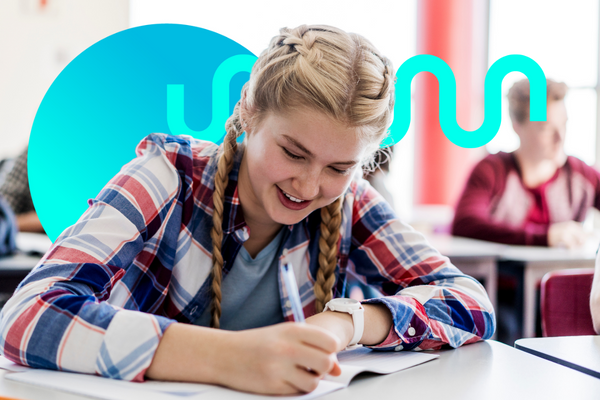 Female student writes on paper in a classroom