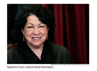 Supreme Court Justice Sonia Sotomayor pictured smiling wearing a judge's robe. 