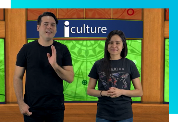 A man and a woman in front of a green screen with the text 